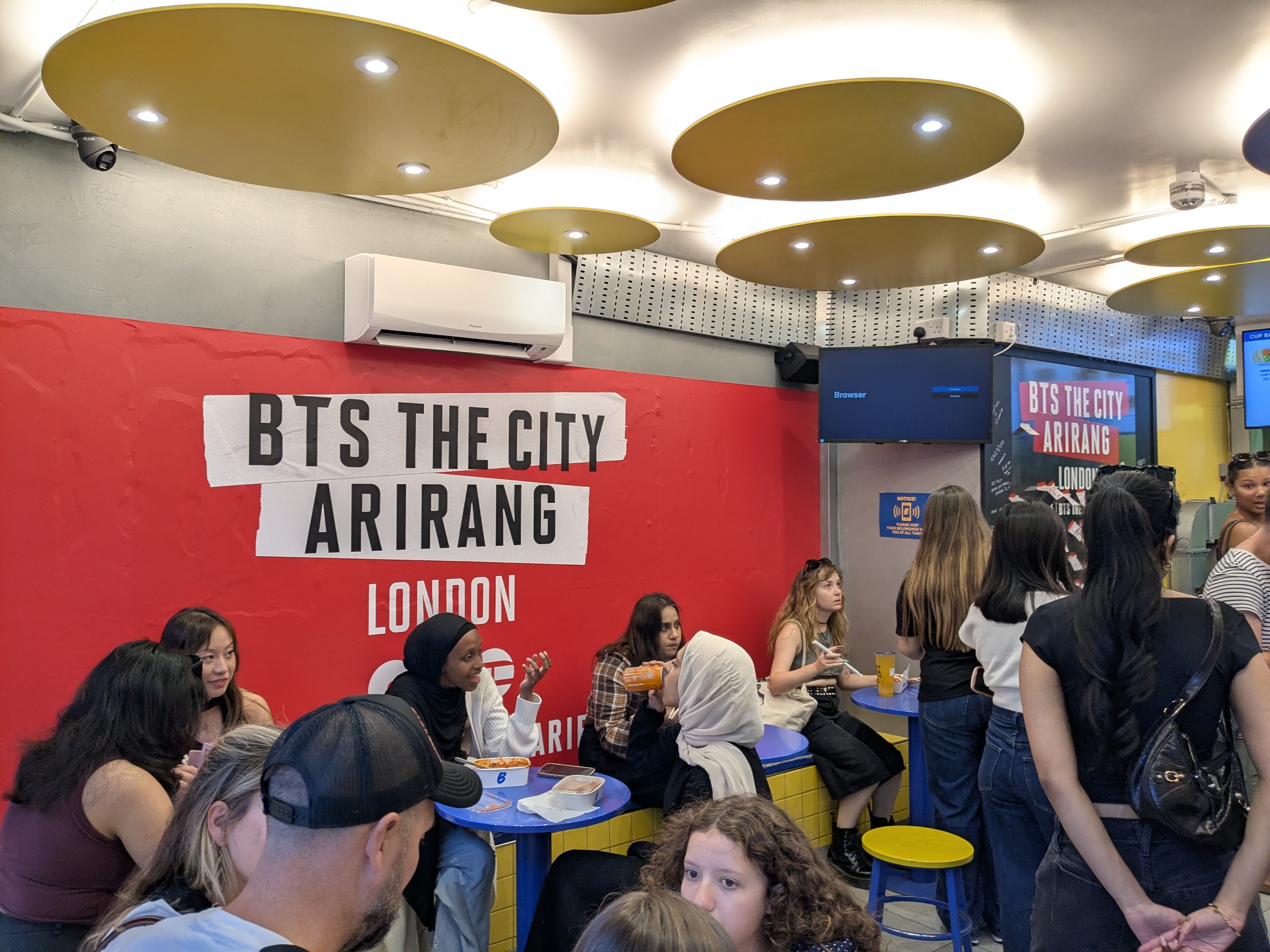 Store interior with BTS wall graphics and customers